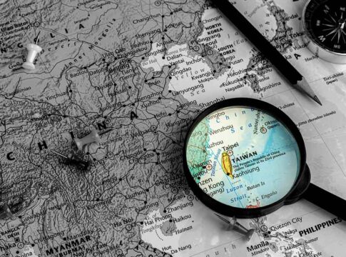 Map of China, Taiwan magnified, surrounded by pins, compass.