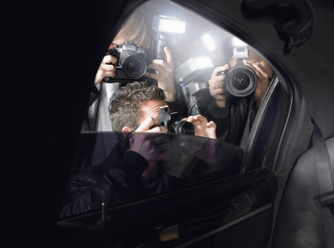 Paparazzi taking photos through a car window.
