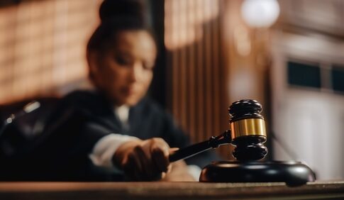 Judge striking gavel in courtroom.