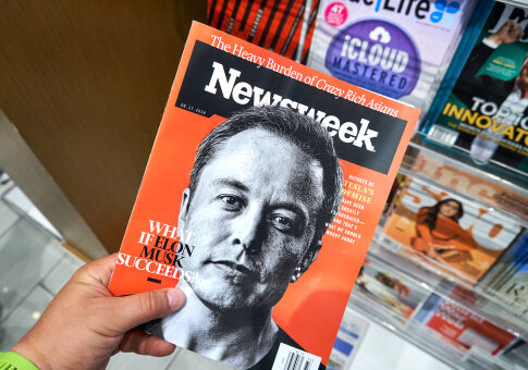 Person holding Newsweek magazine with Elon Musk cover.