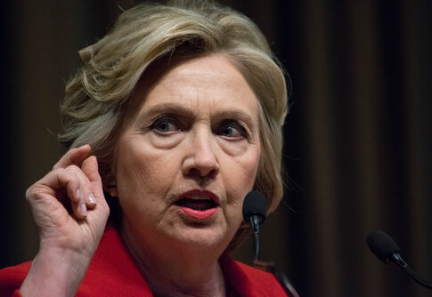Woman speaking at a podium with microphones.