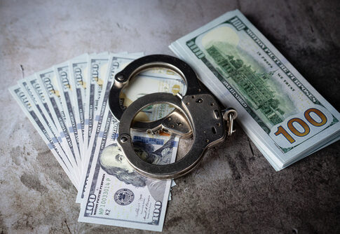 Handcuffs with one hundred dollar bills.