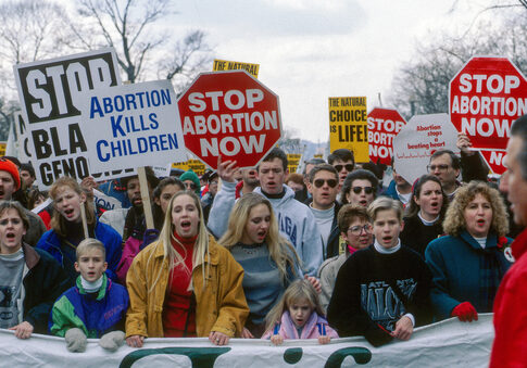 Protesters holding anti-abortion signs at a rally.