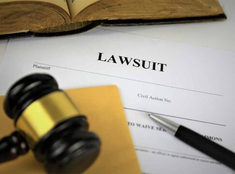 Lawsuit document with gavel, pen, and book.