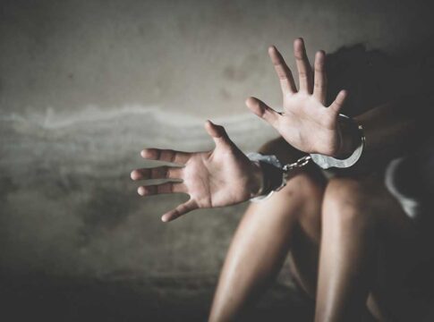 Handcuffed person reaching out in distress.