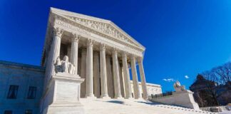 Supreme Court building with columns and statues.