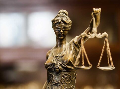 Bronze Lady Justice statue holding scales.