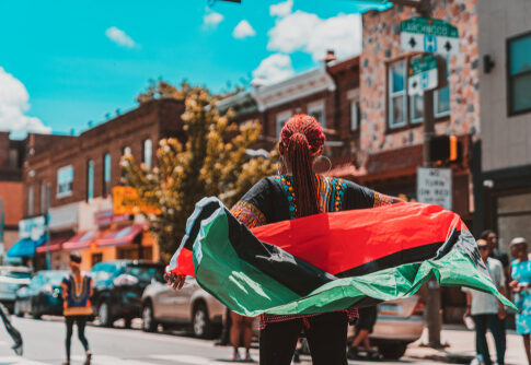 Person holding a flag on a busy street.