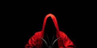 Hooded figure in red cloak holding a goat skull.