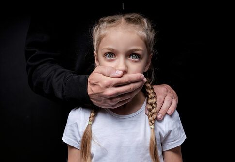 Man covering young girl's mouth with hand.