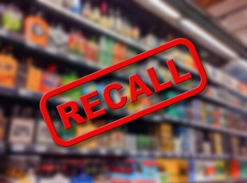 Recall sign over blurred grocery store shelves.