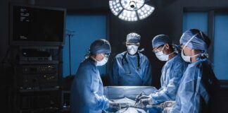 Surgeons operating in an illuminated surgical room