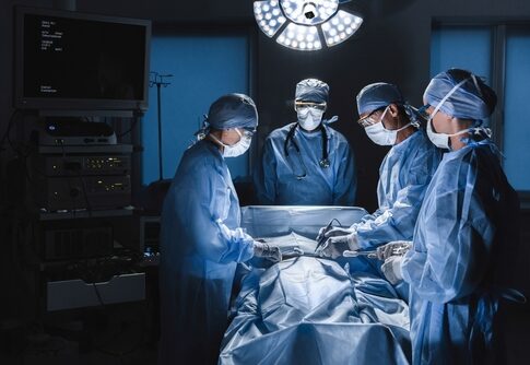 Surgeons operating in an illuminated surgical room