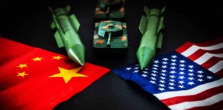 Chinese and American flags with toy missiles and tank.