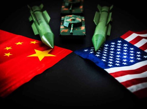 Chinese and American flags with toy missiles and tank.