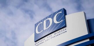 CDC sign on building with cloudy sky background.