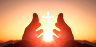Hands reaching toward sun and cross at sunrise.