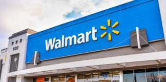 Walmart storefront with people and shopping carts outside.