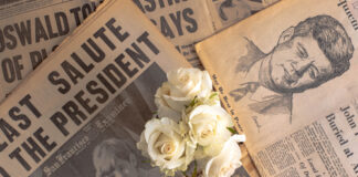 Newspapers, roses, and American flag mourning John F. Kennedy.