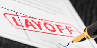 Layoff notice being signed with a pen.