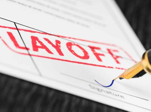 Layoff notice being signed with a pen.