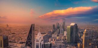City skyline at sunset with modern skyscrapers and colorful sky.
