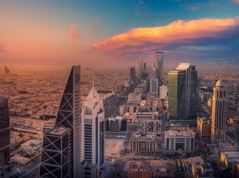 City skyline at sunset with modern skyscrapers and colorful sky.