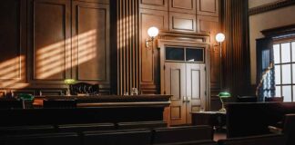 Empty courtroom with sunlight streaming through windows.