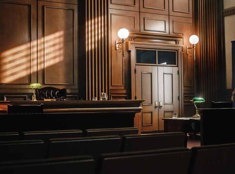 Empty courtroom with sunlight streaming through windows.