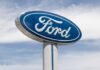 Blue Ford logo sign against the sky.