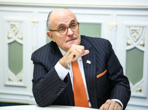 Rudy Giuliani Man in suit sitting at a table indoors