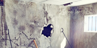 Prison cell escape scene with hole in the wall.