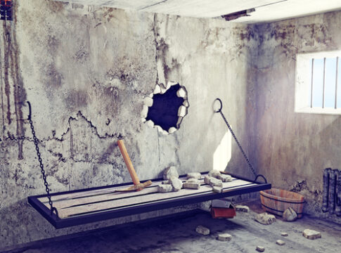 Prison cell escape scene with hole in the wall.