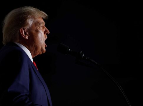 Man speaking into a microphone in the dark