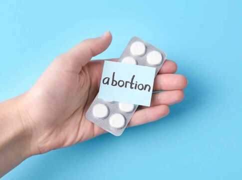 Hand holding pills labeled 