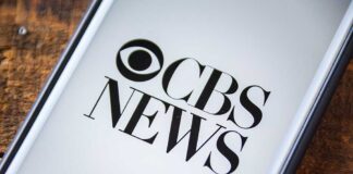 Phone screen showing CBS News logo.