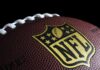 Close-up of NFL logo on brown football.