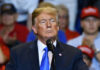Man speaking at a podium during a rally.