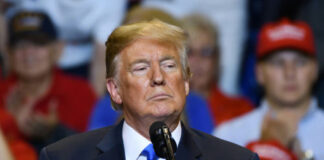 Man speaking at a podium during a rally.