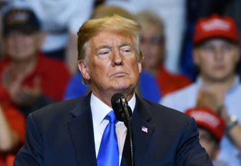 Man speaking at a podium during a rally.