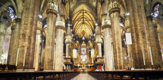 Interior of a grand cathedral with empty pews.