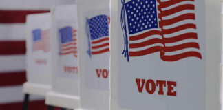 Voting booths with American flags and VOTE signs