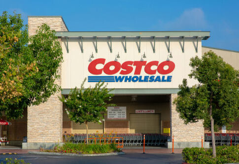 Costco Wholesale storefront with trees and empty shopping carts.