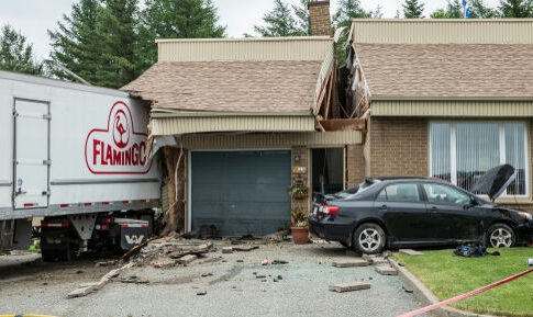 Truck crashed into house with damaged garage and car