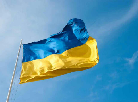 Ukrainian flag waving against blue sky.