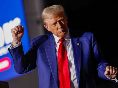 Man in blue suit with red tie speaking